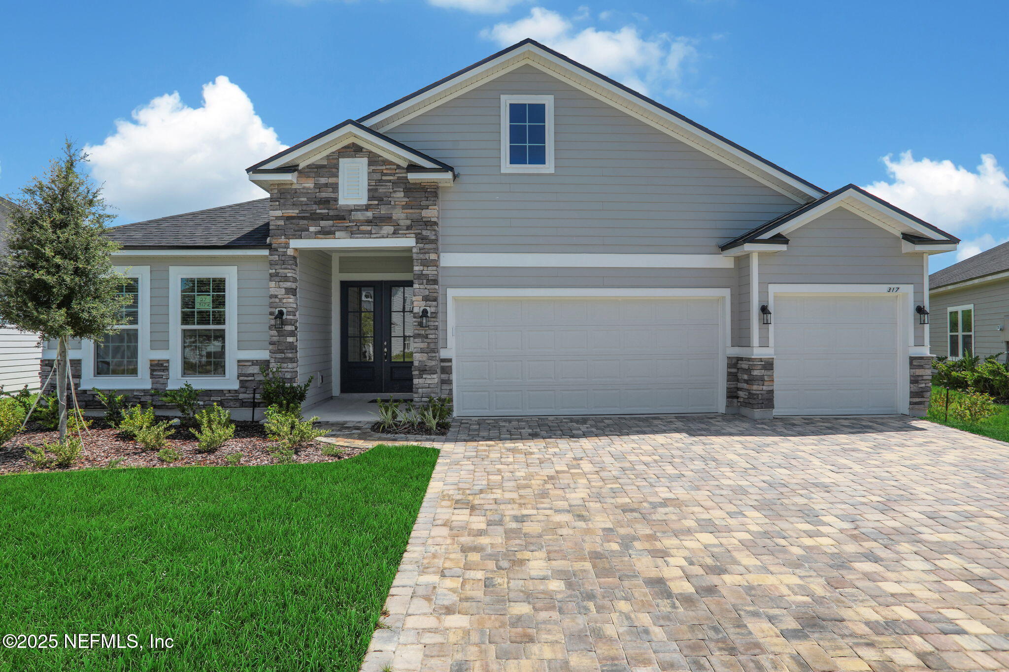 317 Archstone Way St. Augustine, FL 32092 - Photo 5 of 46 a front view of a house with a yard and garage