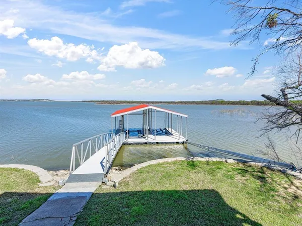 a view of a house with swimming pool lawn chairs and a yard