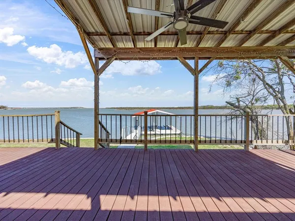 a view of a balcony with chairs and wooden floor