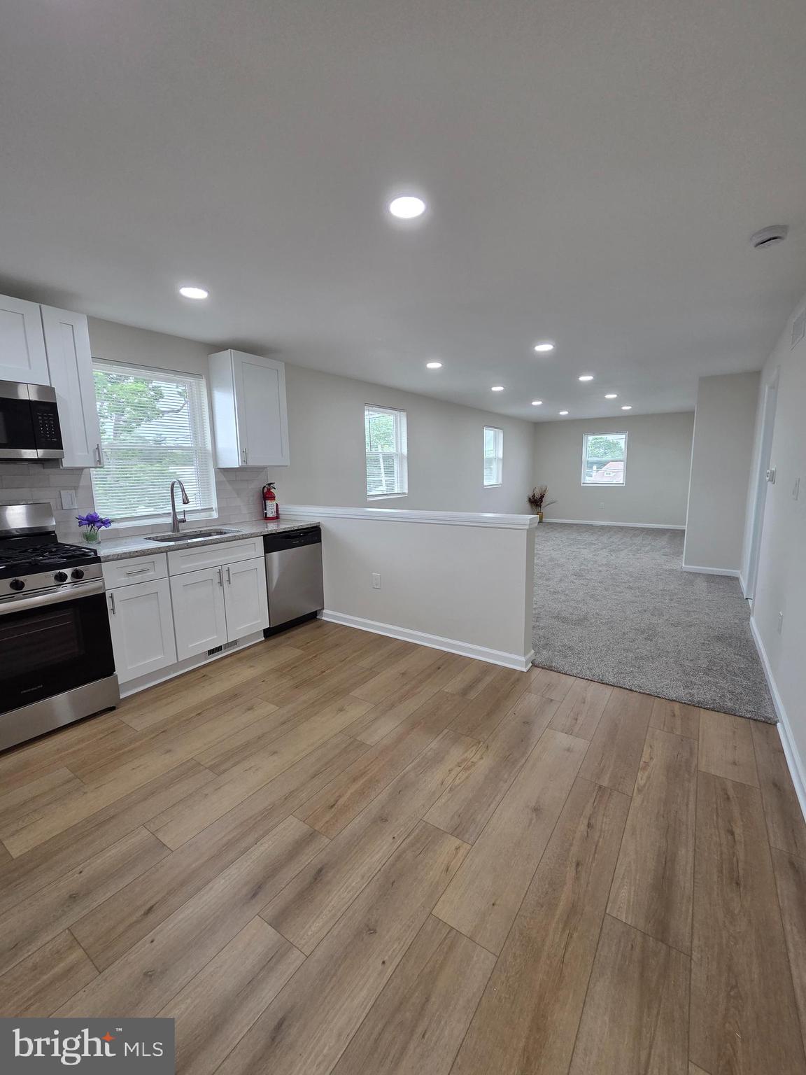 a large kitchen with stainless steel appliances granite countertop a large counter top and a stove top oven