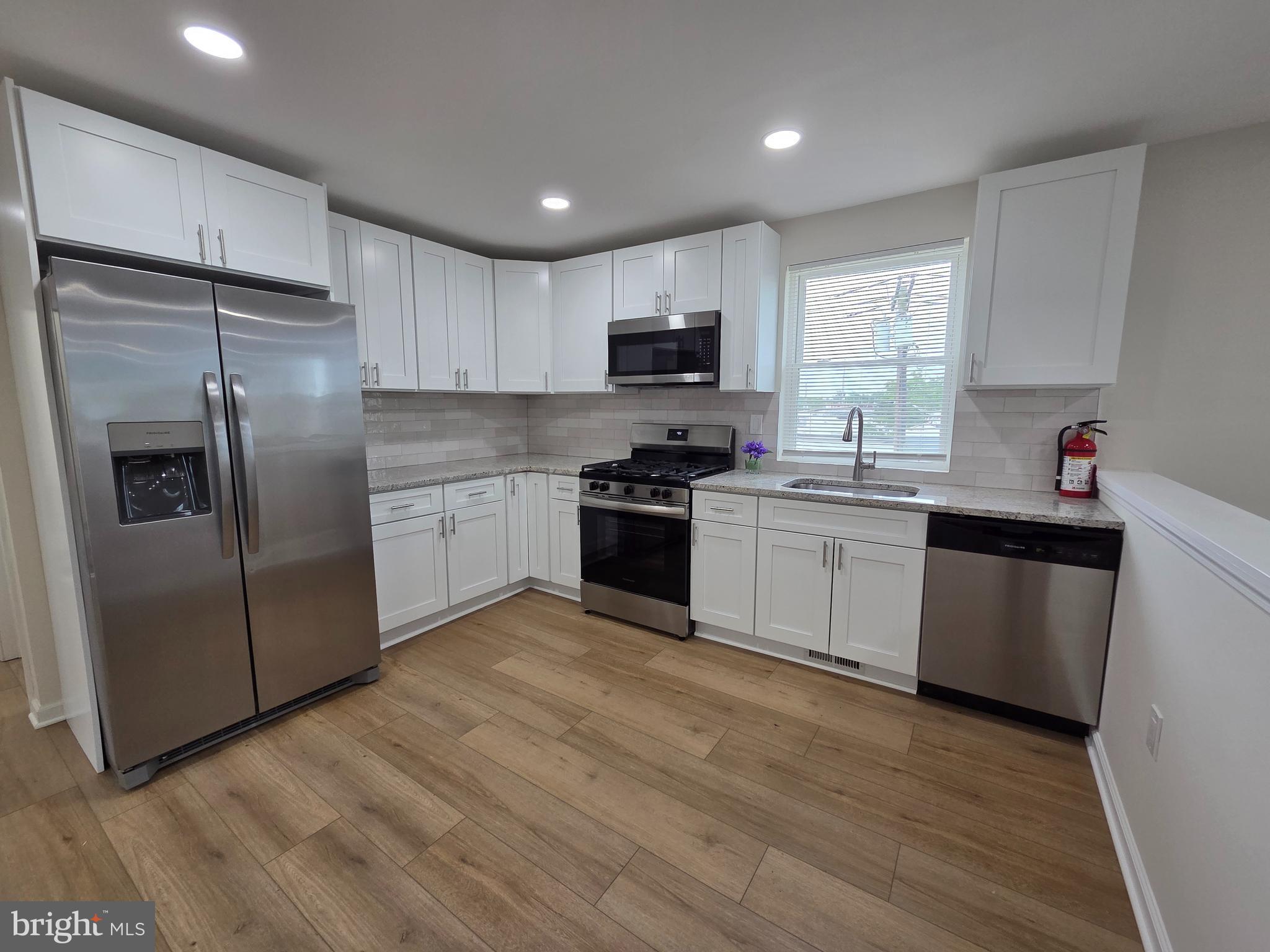 102 East Clements Bridge Road, Unit 2 Runnemede, NJ 08078 - Photo 2 of 18 a kitchen with a sink a refrigerator a window and cabinets