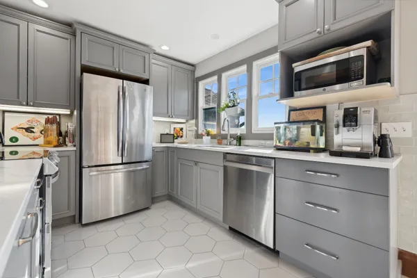 a kitchen with stainless steel appliances a refrigerator sink and microwave