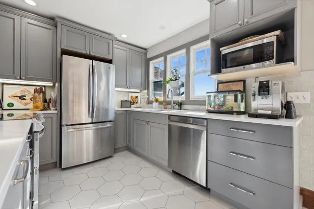 a kitchen with stainless steel appliances a refrigerator sink and microwave