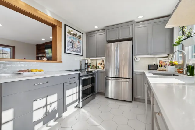 a kitchen with stainless steel appliances a refrigerator sink and microwave