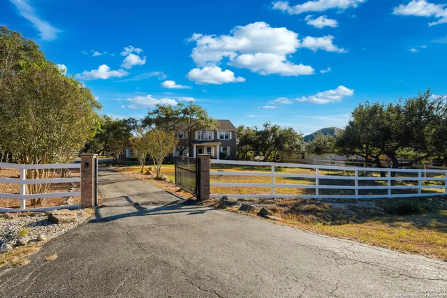 a view of a swimming pool with a bench and trees in the background
