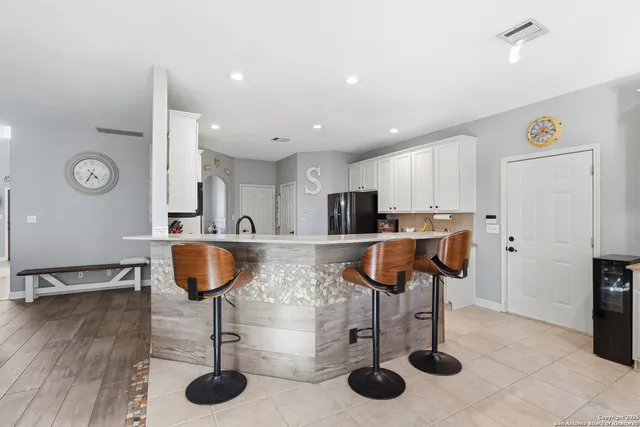 a kitchen with stainless steel appliances kitchen island granite countertop a sink and a refrigerator