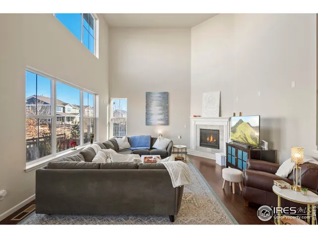 a living room with furniture a fireplace and a floor to ceiling window