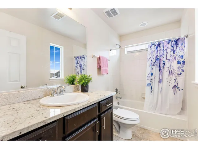 a bathroom with a granite countertop sink toilet a large mirror and shower