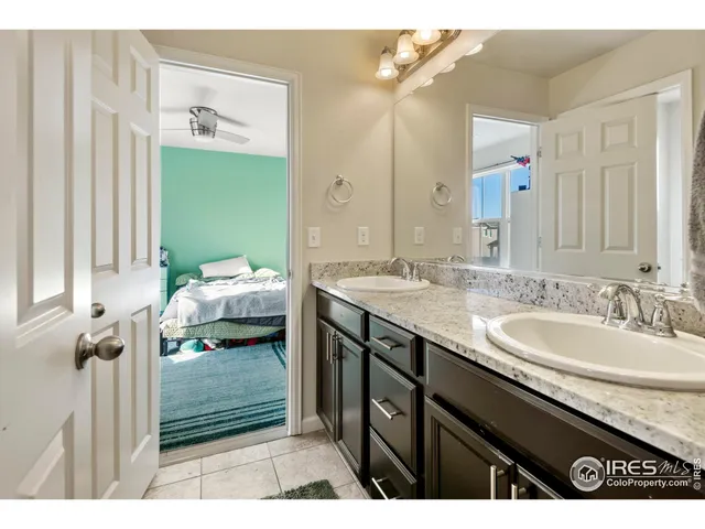 a en suite bathroom with a granite countertop sink and a mirror