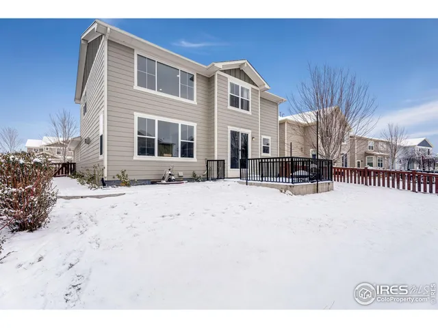 a front view of a house with a yard covered with snow