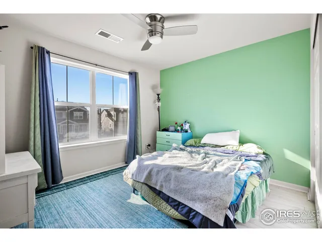 a bedroom with a bed table and a window