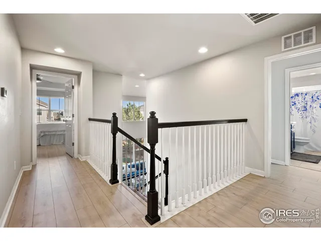 a view of a hallway with wooden floor and windows