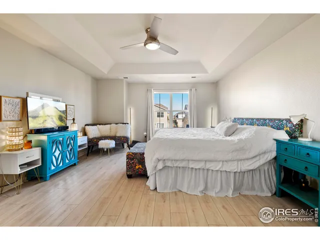 a spacious bedroom with a bed and a flat screen tv