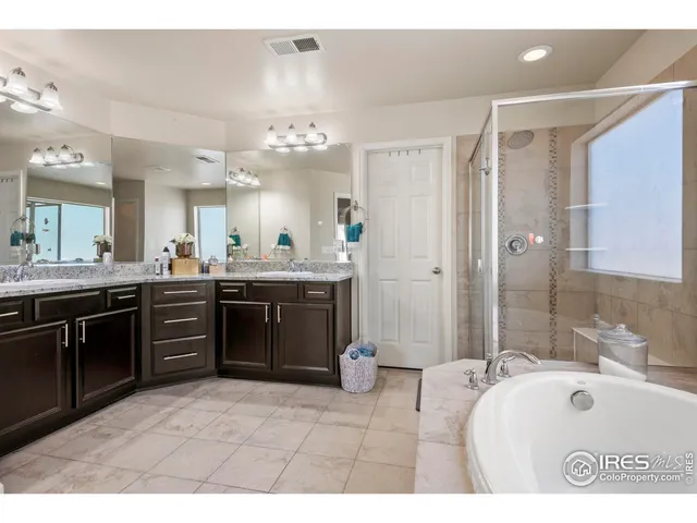 a spacious bathroom with a sink a vanity a mirror a bathtub and shower