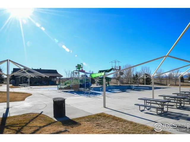 a view of a swimming pool with lawn chairs under an umbrella