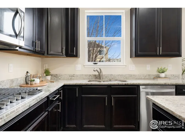 a kitchen with stainless steel appliances granite countertop a sink stove and cabinets
