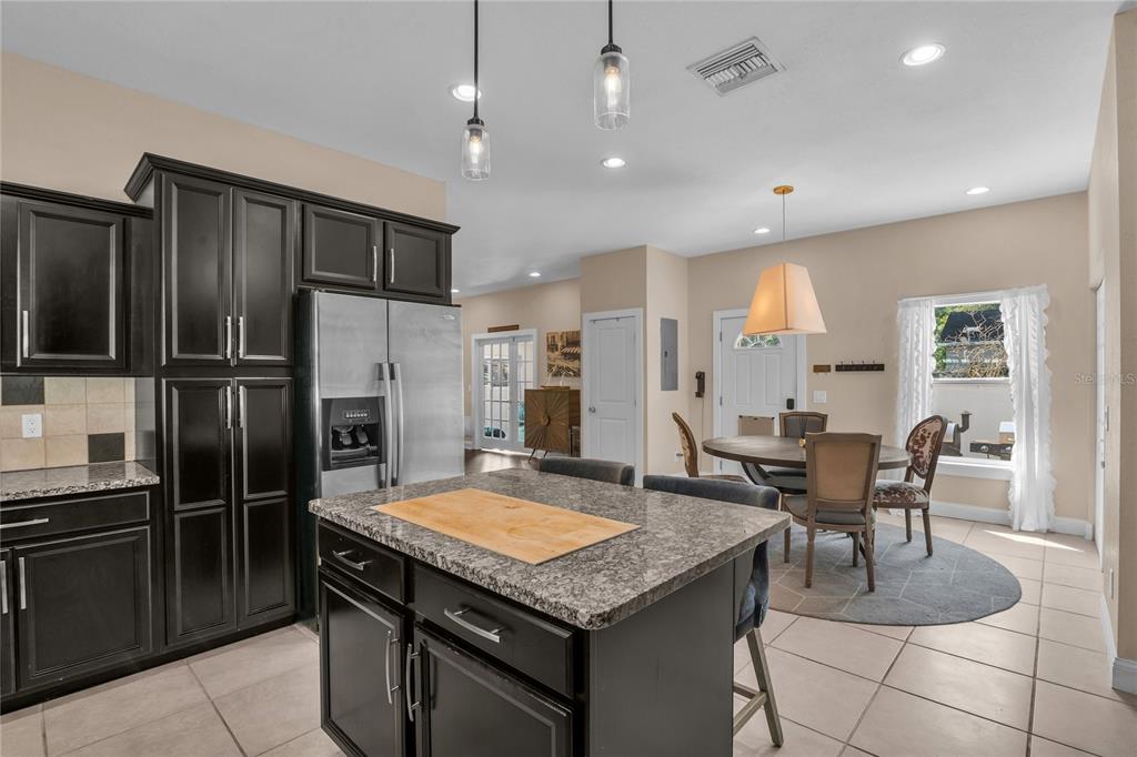 2414 Newberry Street Orlando, FL 32806 - Photo 12 of 36 a kitchen with granite countertop kitchen island stainless steel appliances a table and chairs