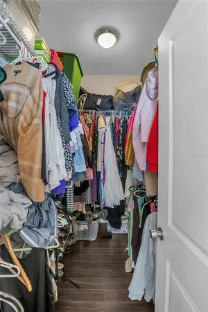 a view of walk in closet with clothes and shoes