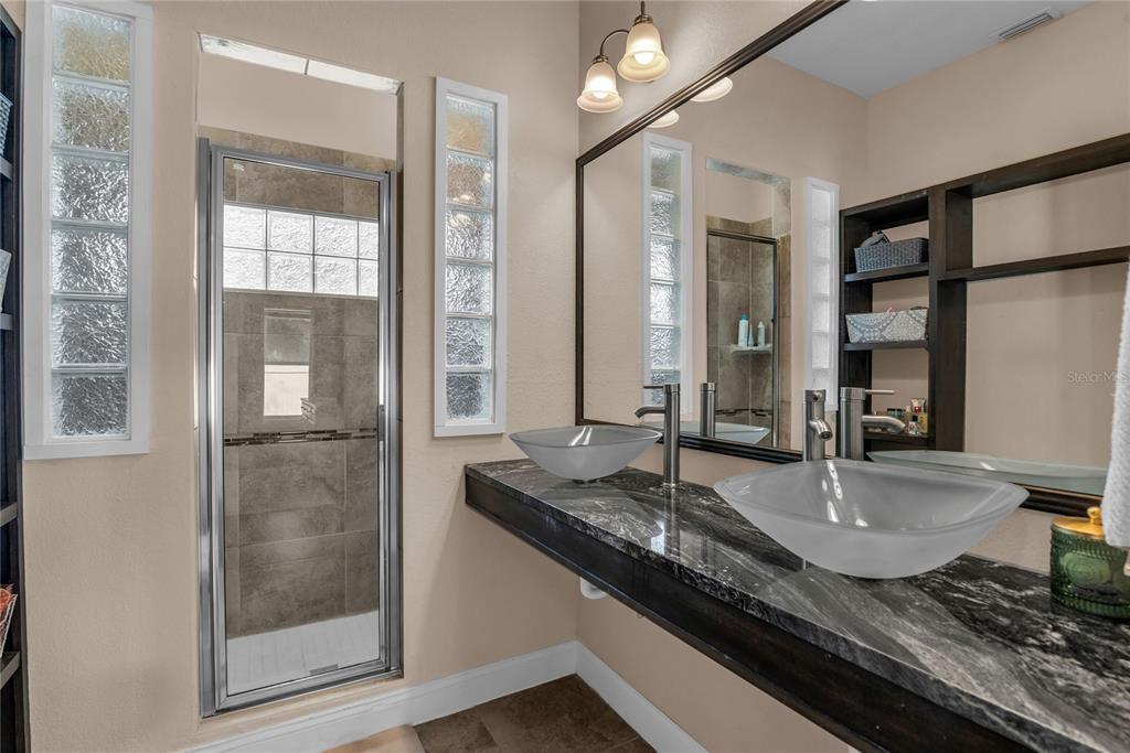 2414 Newberry Street Orlando, FL 32806 - Photo 18 of 36 a bathroom with a granite countertop sink and a mirror