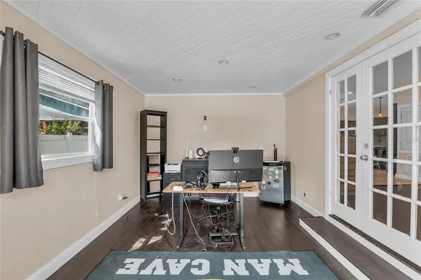 a work room with furniture a rug and a window