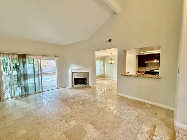 a view of an empty room with a fireplace and a window