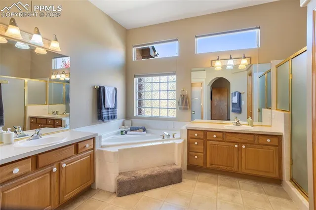 a spacious bathroom with a double vanity sink a mirror and a bathtub