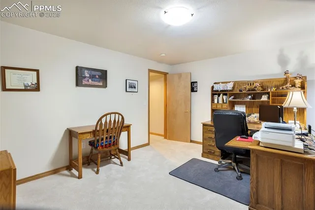 a view of a workspace with furniture and a window