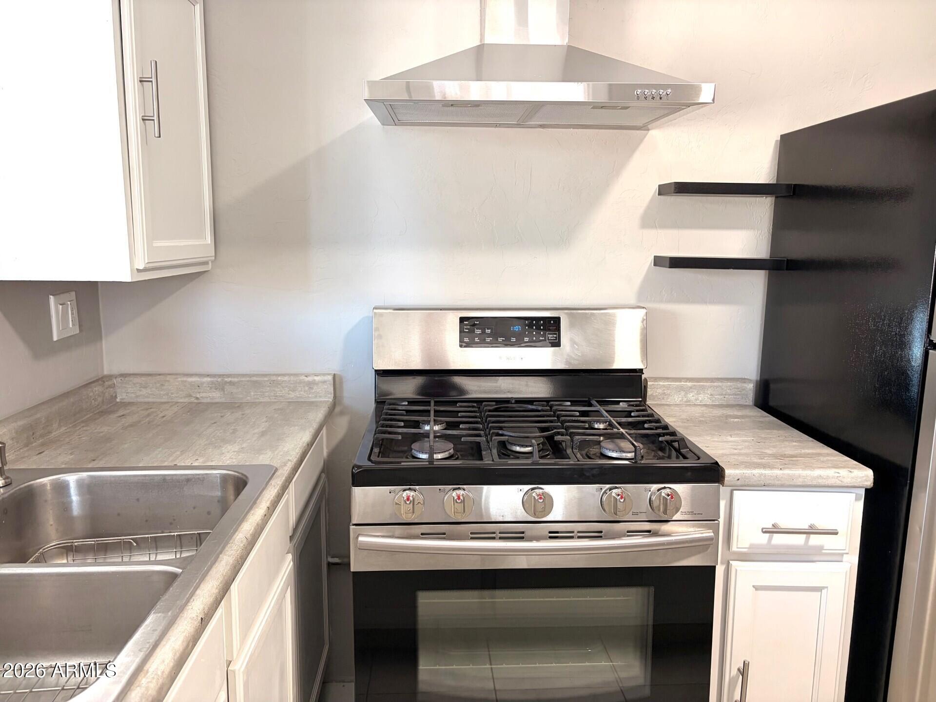 826 1st Street Douglas, AZ 85607 - Photo 5 of 35 a stove top oven sitting inside of a kitchen