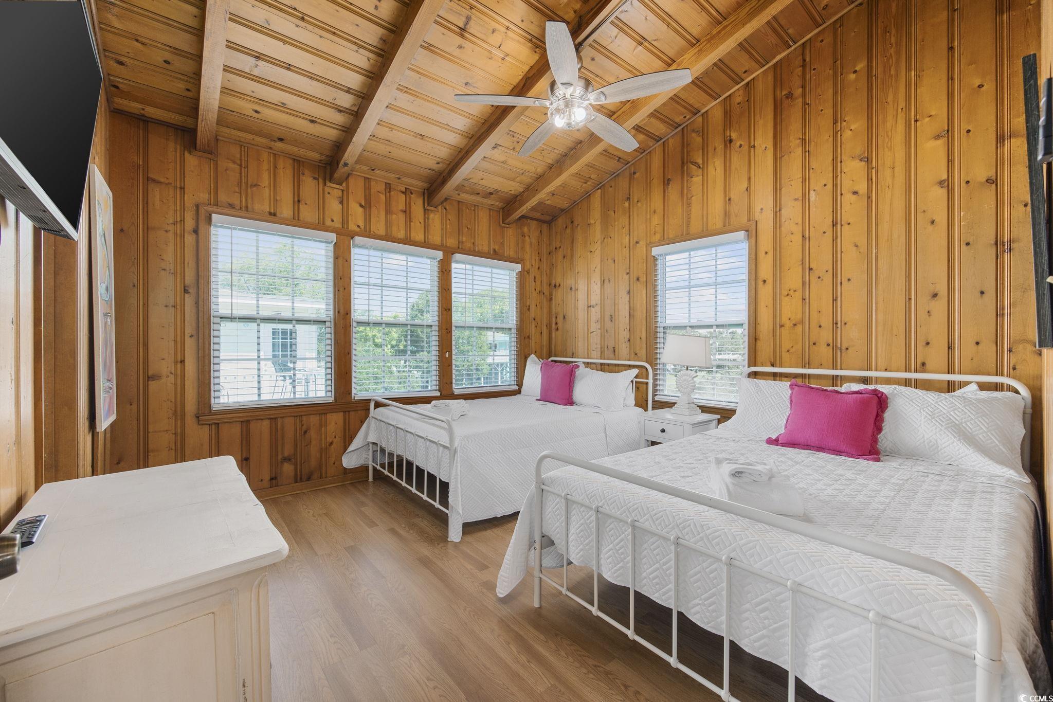 222 Calhoun Drive Murrells Inlet, SC 29576 - Photo 10 of 40 Bedroom featuring wood walls, light wood-type flooring, lofted ceiling with beams, ceiling fan, and wooden ceiling