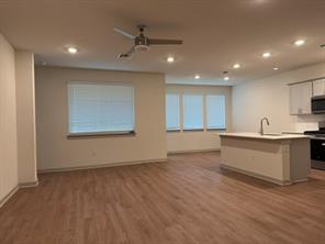 10609 Defender Trail Austin, TX 78754 - Photo 11 of 11 An open floorplan seamlessly connects the kitchen with a spacious living area, highlighted by recessed lighting and rich wood flooring.