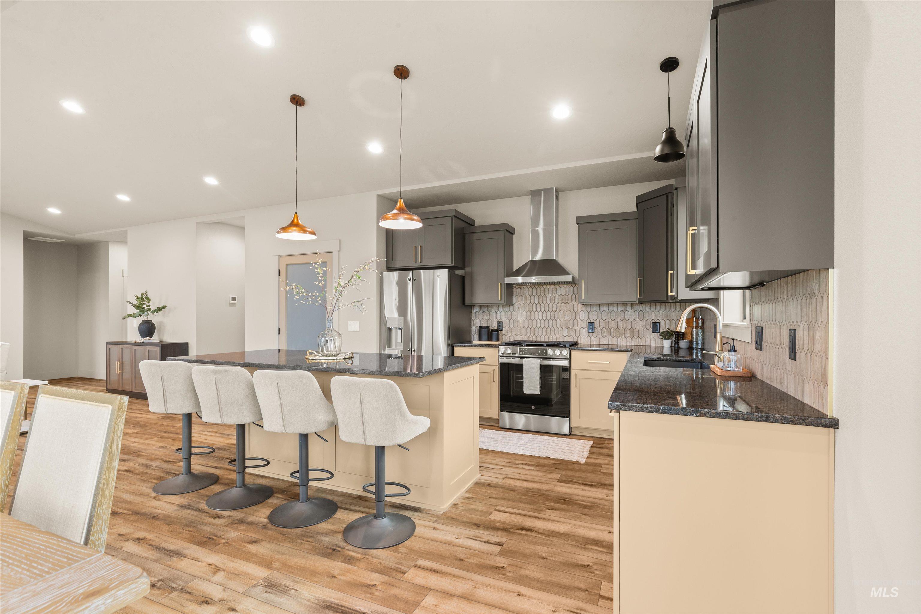 335 Warner Avenue Lewiston, ID 83501 - Photo 9 of 43 Kitchen with stainless steel appliances, dark stone countertops, decorative light fixtures, and a center island