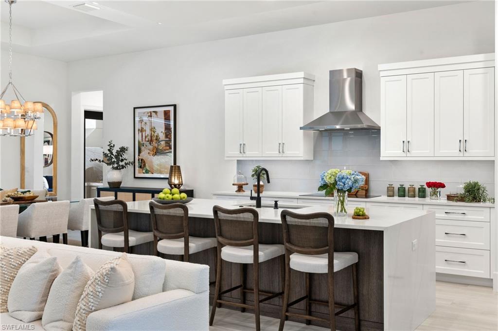 4221 7th Avenue Northwest Naples, FL 34119 - Photo 11 of 42 a kitchen with stainless steel appliances a table chairs stove and cabinets