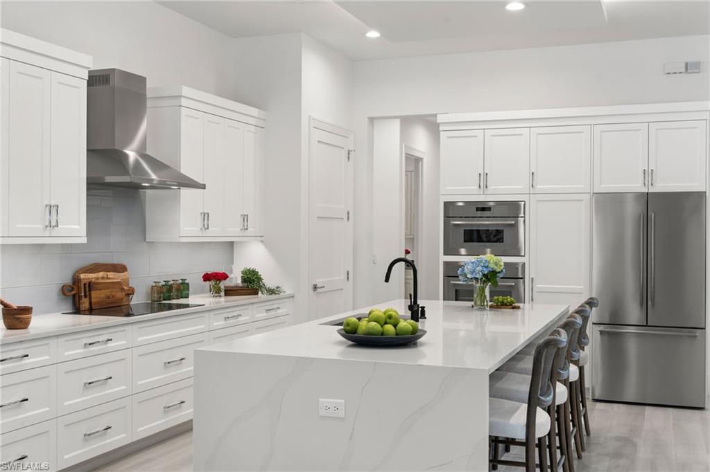 4221 7th Avenue Northwest Naples, FL 34119 - Photo 12 of 42 a kitchen with sink a refrigerator and cabinets