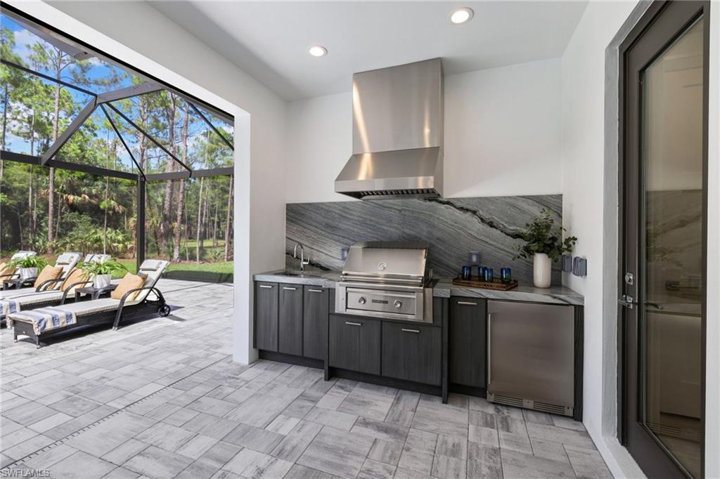 4221 7th Avenue Northwest Naples, FL 34119 - Photo 31 of 42 a kitchen with stainless steel appliances granite countertop a stove a sink and a refrigerator