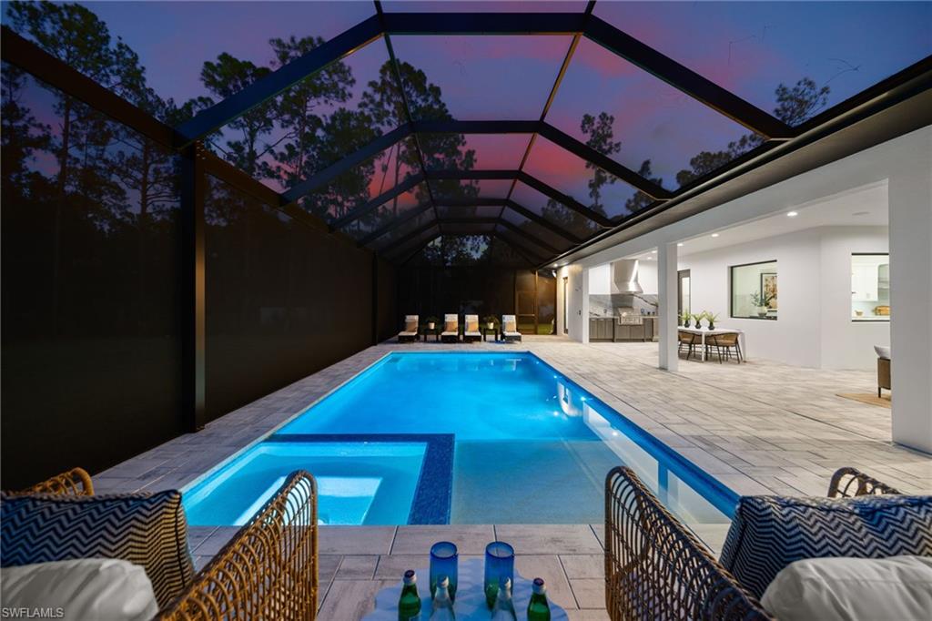 4221 7th Avenue Northwest Naples, FL 34119 - Photo 39 of 42 a view of a patio with table and chairs with wooden floor