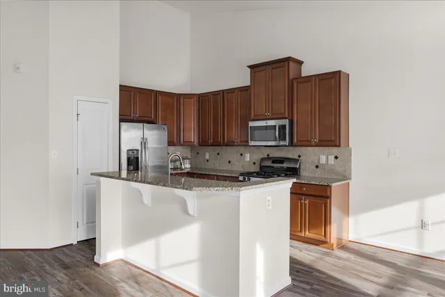 a kitchen with stainless steel appliances granite countertop a stove a sink and a microwave