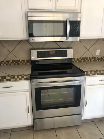 a stove top oven sitting inside of a kitchen