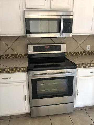 a stove top oven sitting inside of a kitchen