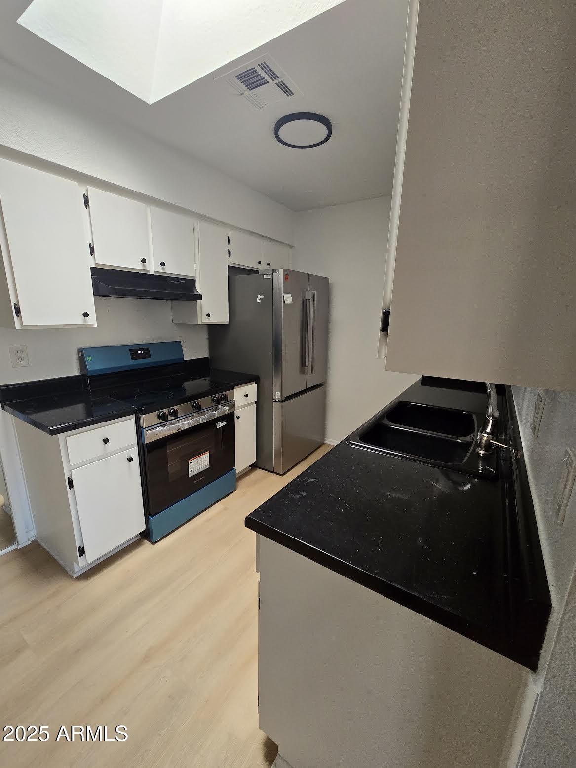 97 North Cooper Road, Unit 86 Chandler, AZ 85225 - Photo 5 of 16 a kitchen with granite countertop a refrigerator and a stove