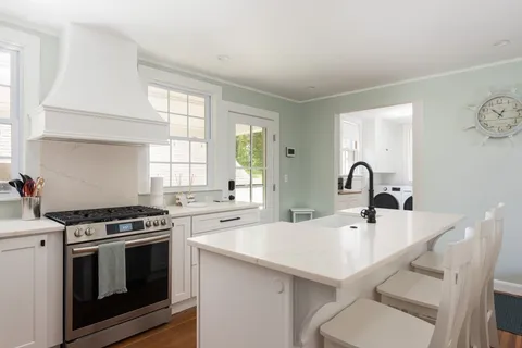 a kitchen with white cabinets and refrigerator