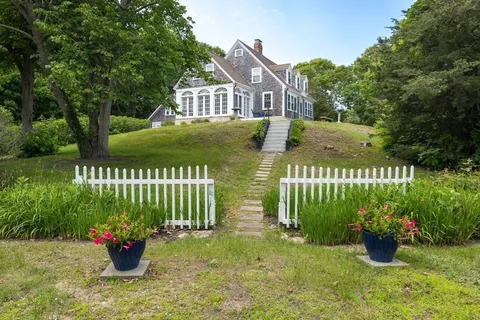 a front view of a house with swimming pool and garden