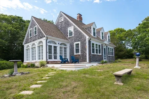 a view of a house with a yard and potted plants