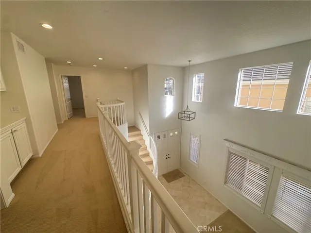 a view of a hallway with furniture and stairs