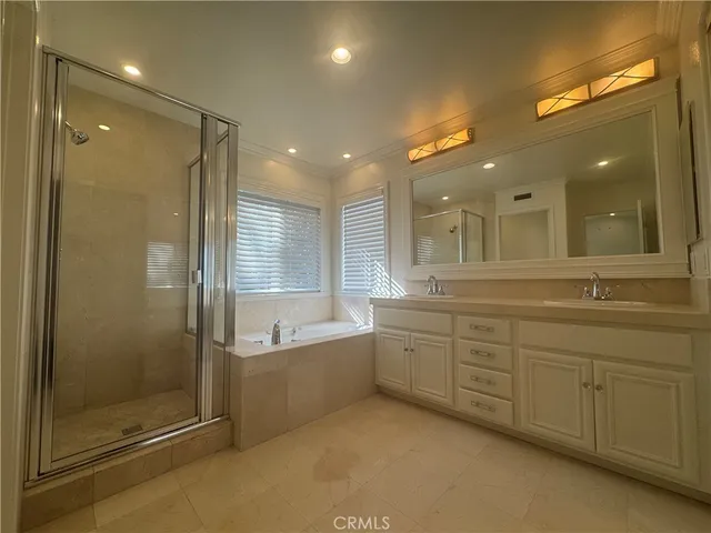 a bathroom with a mirror a double vanity sink and a shower