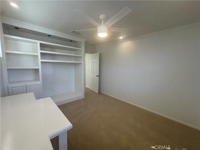 a view of an empty room with a ceiling fan