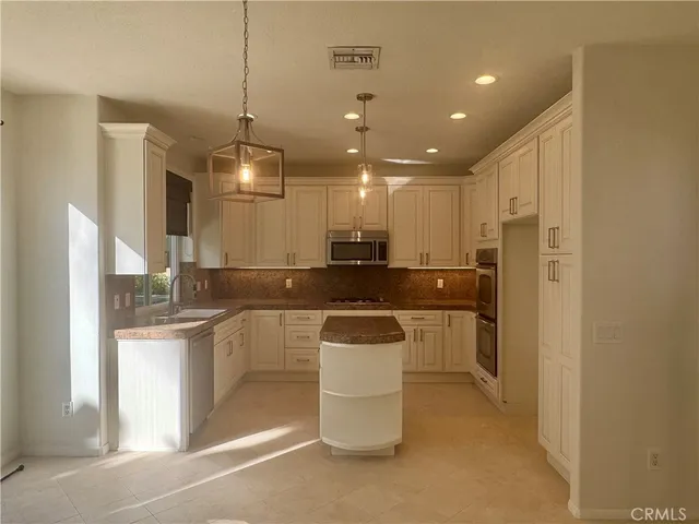 a kitchen with a sink and stainless steel appliances
