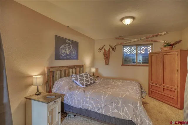 a bedroom with a bed and a painting on the wall