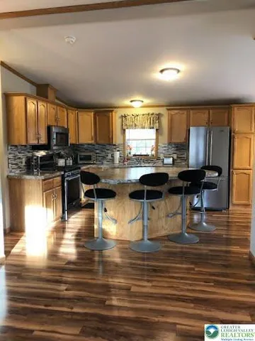 a kitchen with granite countertop a stove a sink and a refrigerator