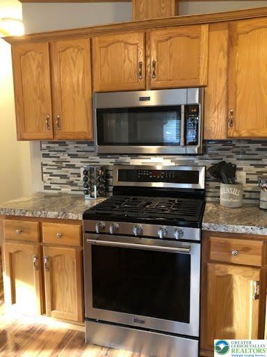 4905 Cedar Grove Road Bangor, PA 18013 - Photo 17 of 50 a kitchen with granite countertop a stove top oven microwave and cabinets