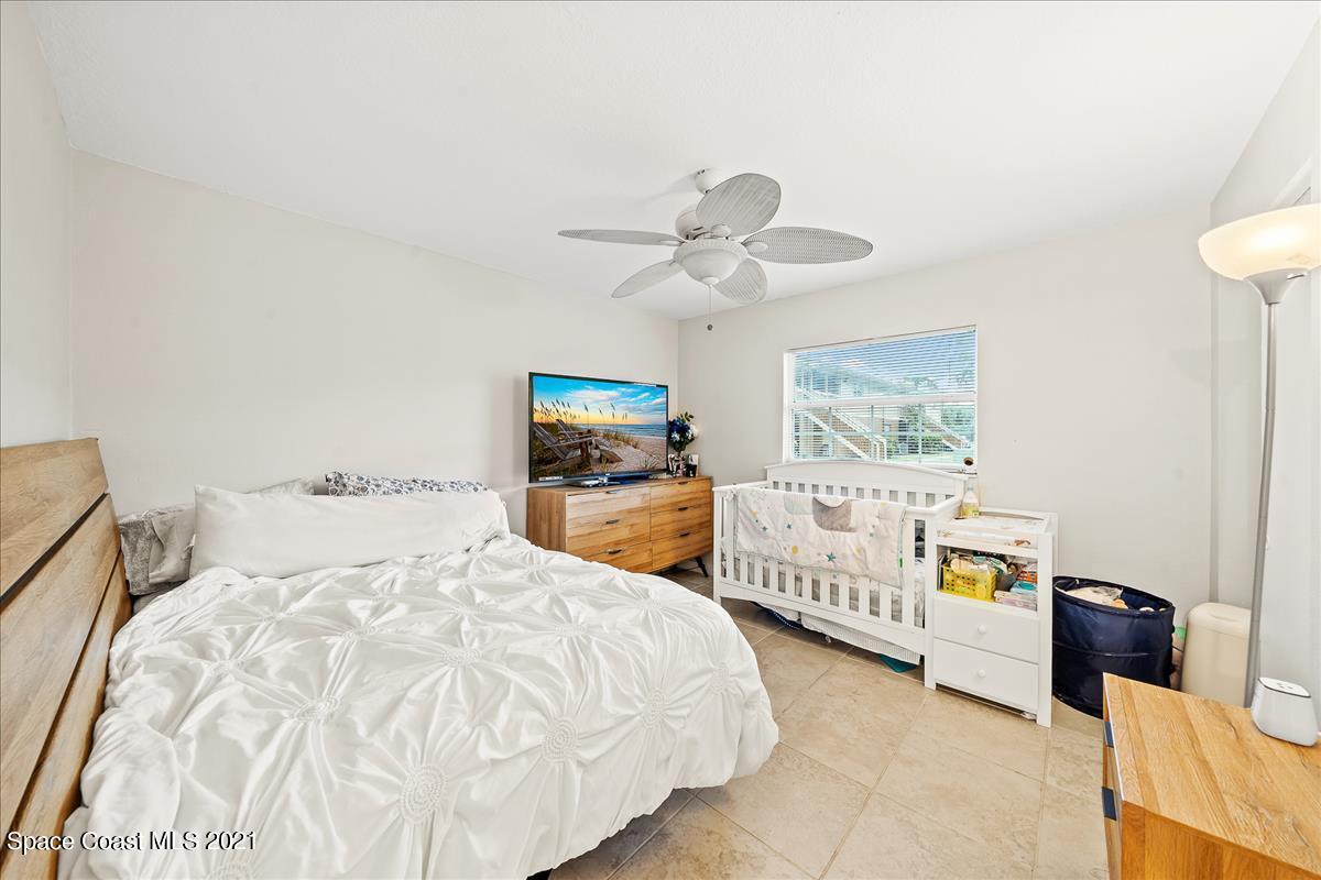 151 Ulster Lane Melbourne, FL 32935 - Photo 12 of 14 a bedroom with a bed and a chandelier